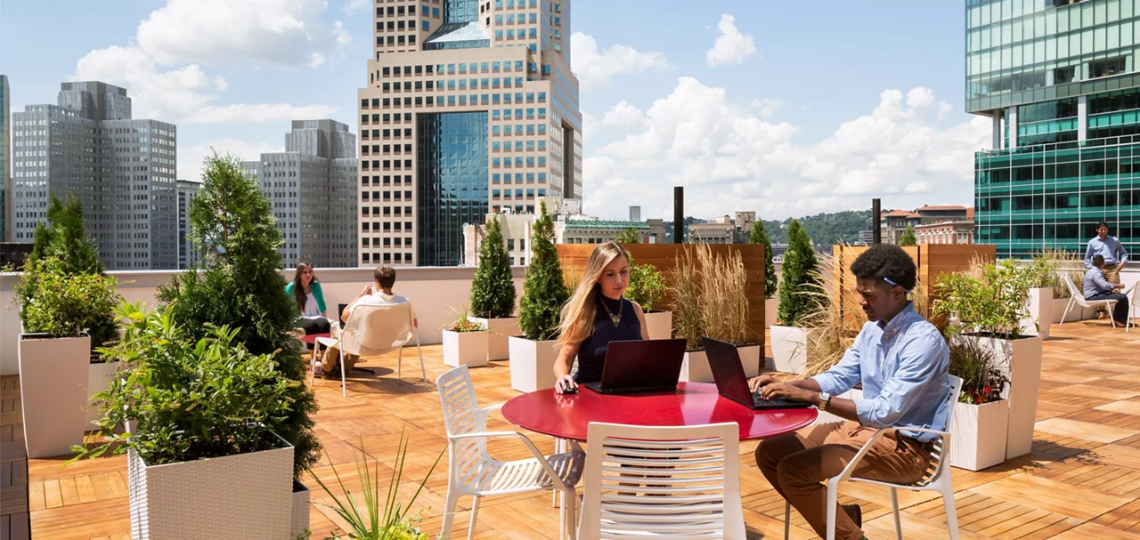 Two office workers collaborate on a rooftop terrasse of a Corporate building