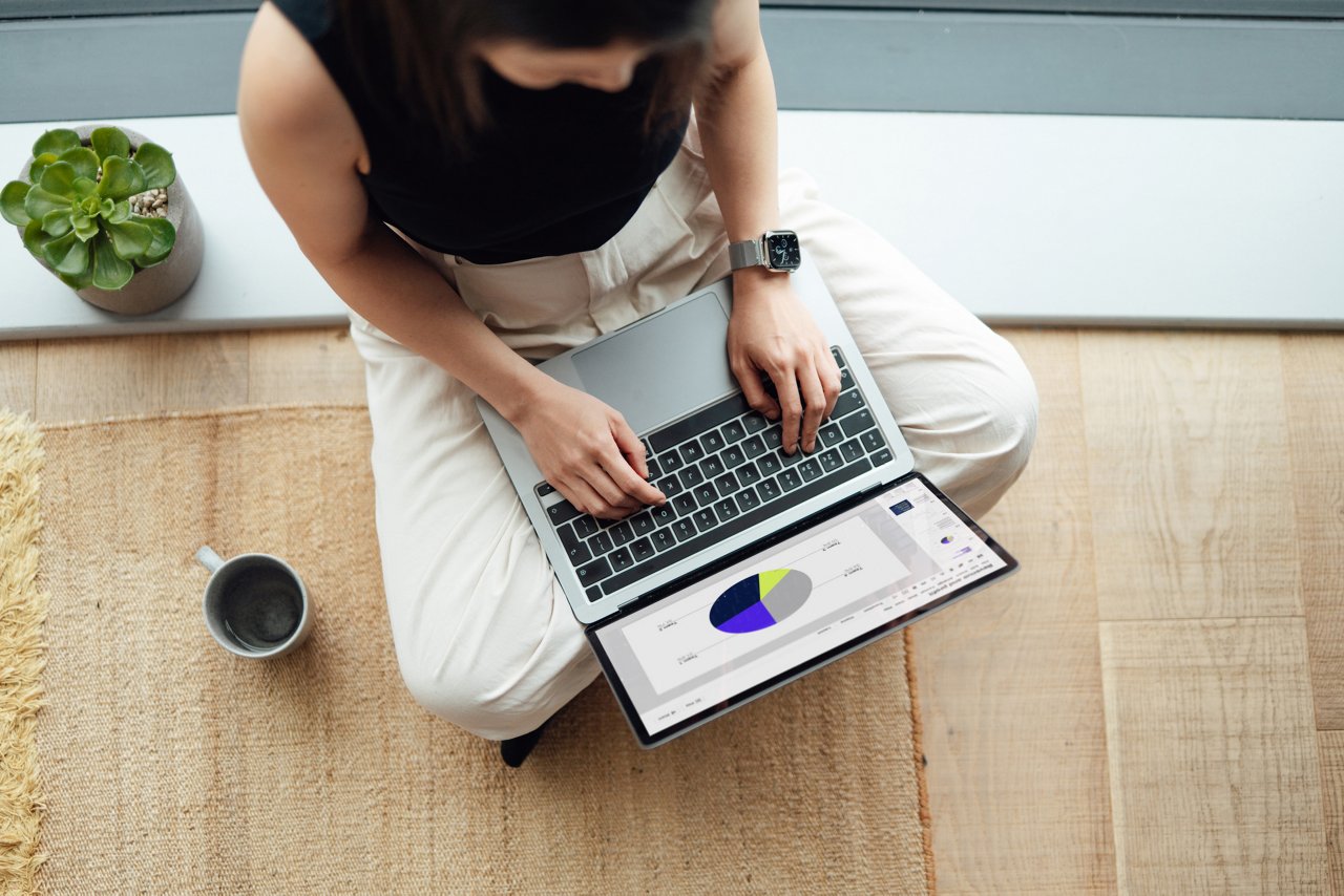 Woman working on laptop, sitting on the floor