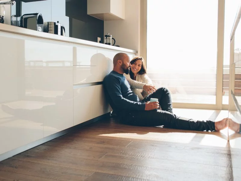 Couple sitting on the kitchen floor.