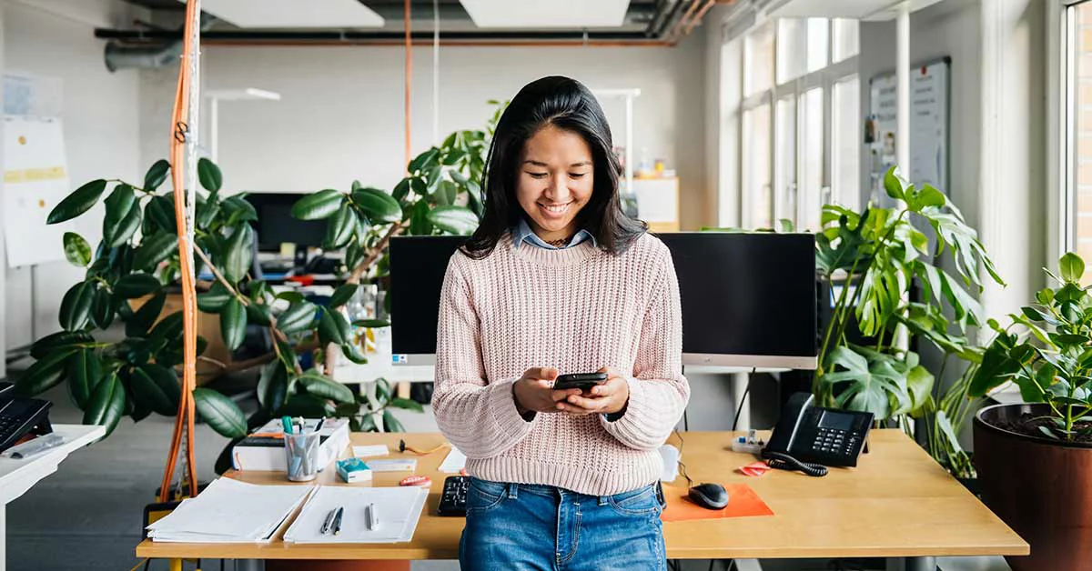 Happy employee in a green office, smiling.