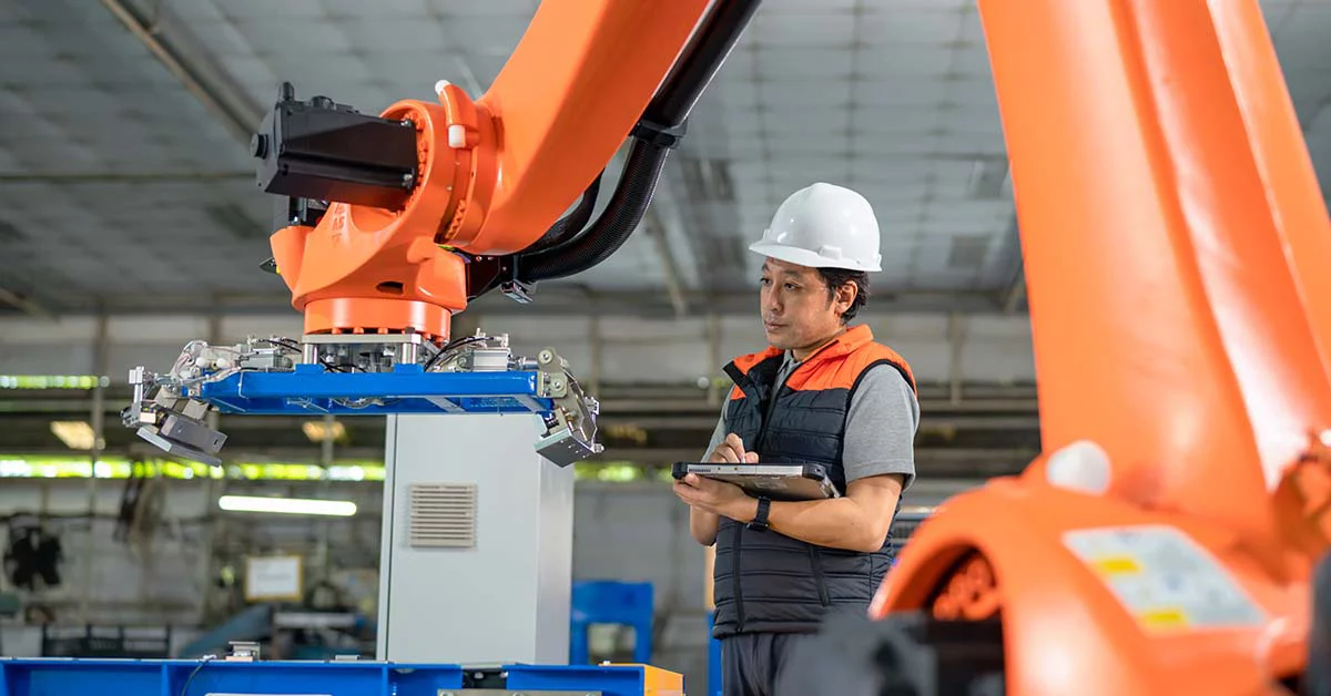 Employee noting down the readings from the machine in the factory