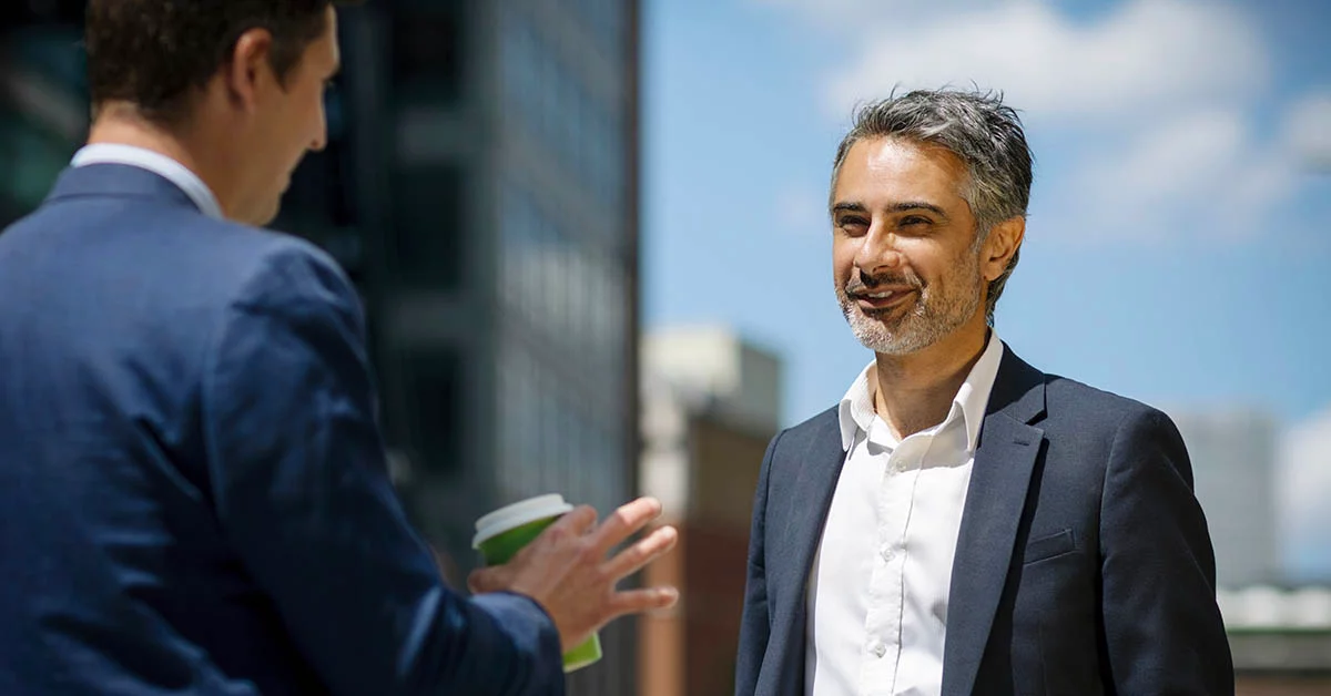 Two men speaking at outside