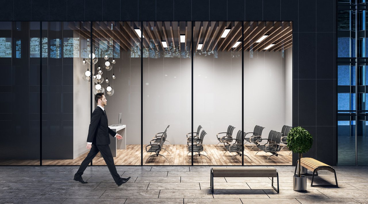 Walking in the evening on a street with spacious conference room with lights, black chairs and wooden floor.