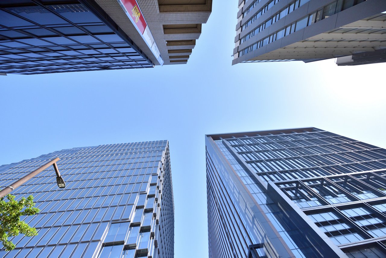 見上げると大規模ビルが視界に飛び込んでくる光景