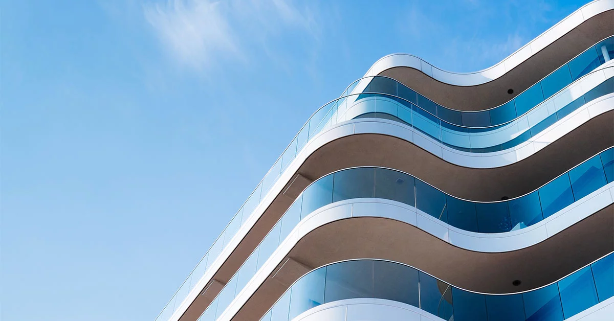 New build apartment building with wavy balconies set against a blue sky