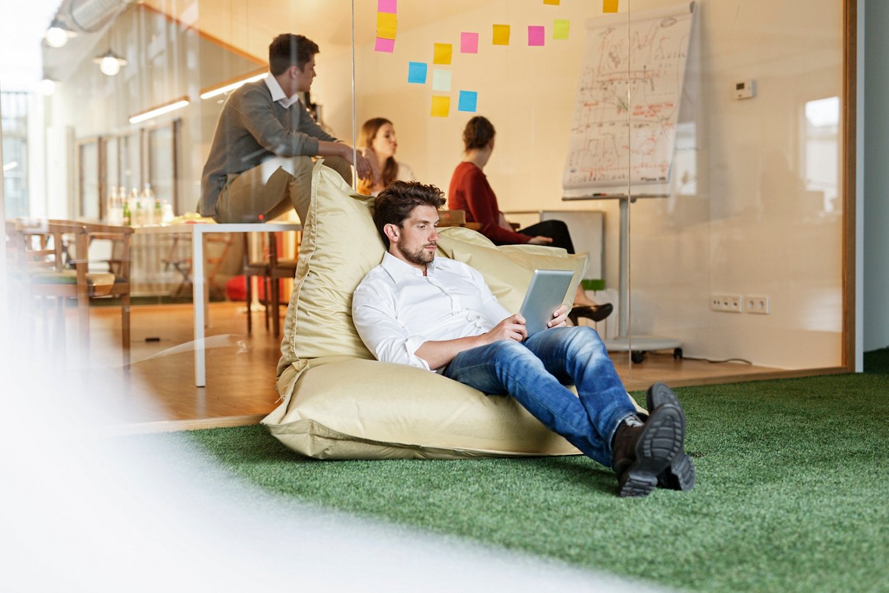 ABW型オフィスでリラックスして働く従業員