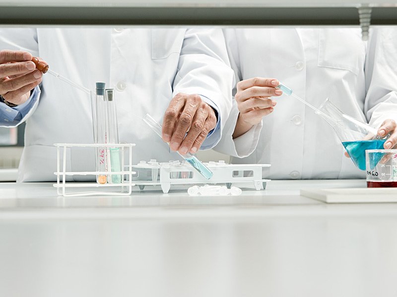 Laboratory scientists in white coats conducting chemical experiments