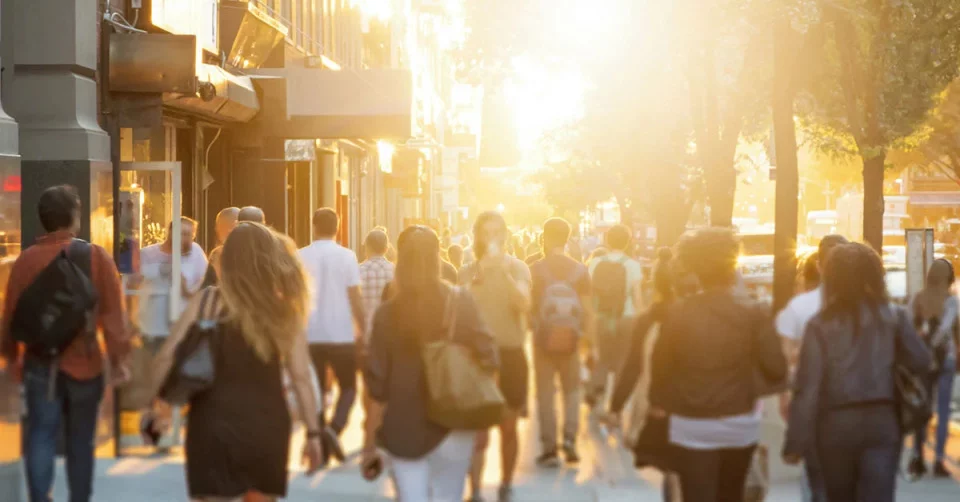 Varias pessoas a camninhar na rua ao fim do dia