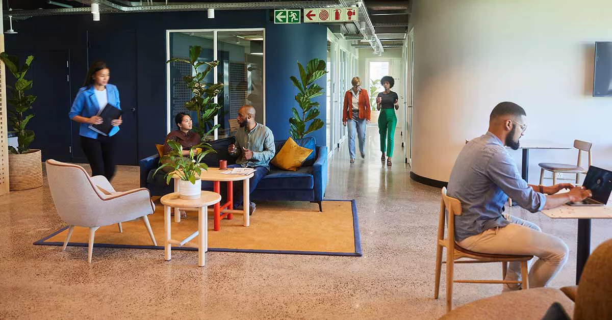 Employees having conversation and sitting in the office entrance area