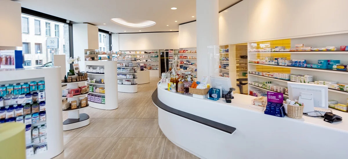 A pharmacy interior featuring numerous shelves stocked with various health and wellness products.
