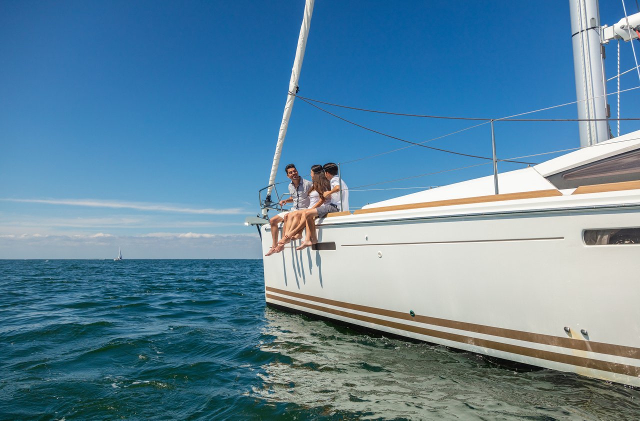 Hispanic family sailing luxury yacht in tropical ocean