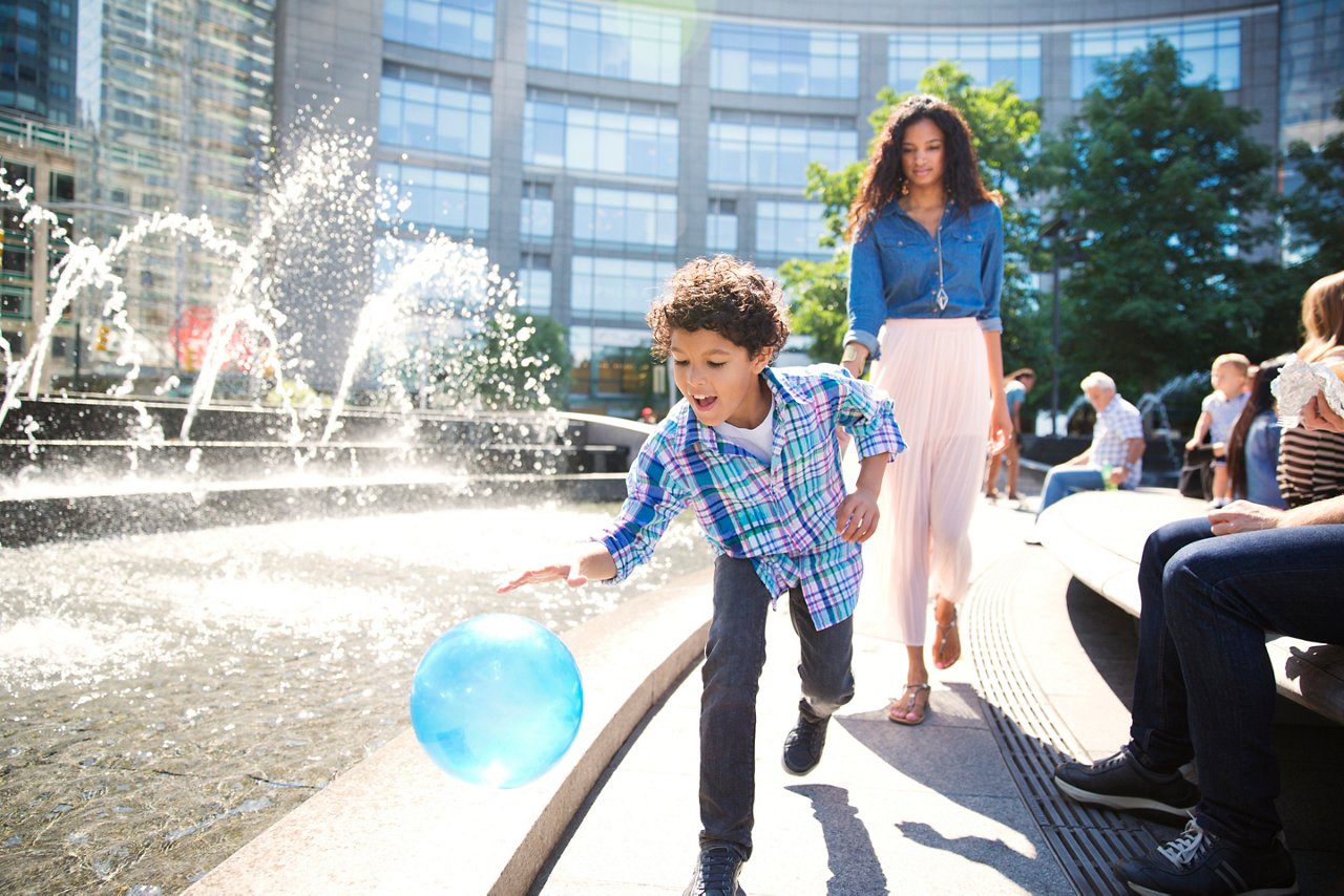 Playful boy with mother walking on footpath