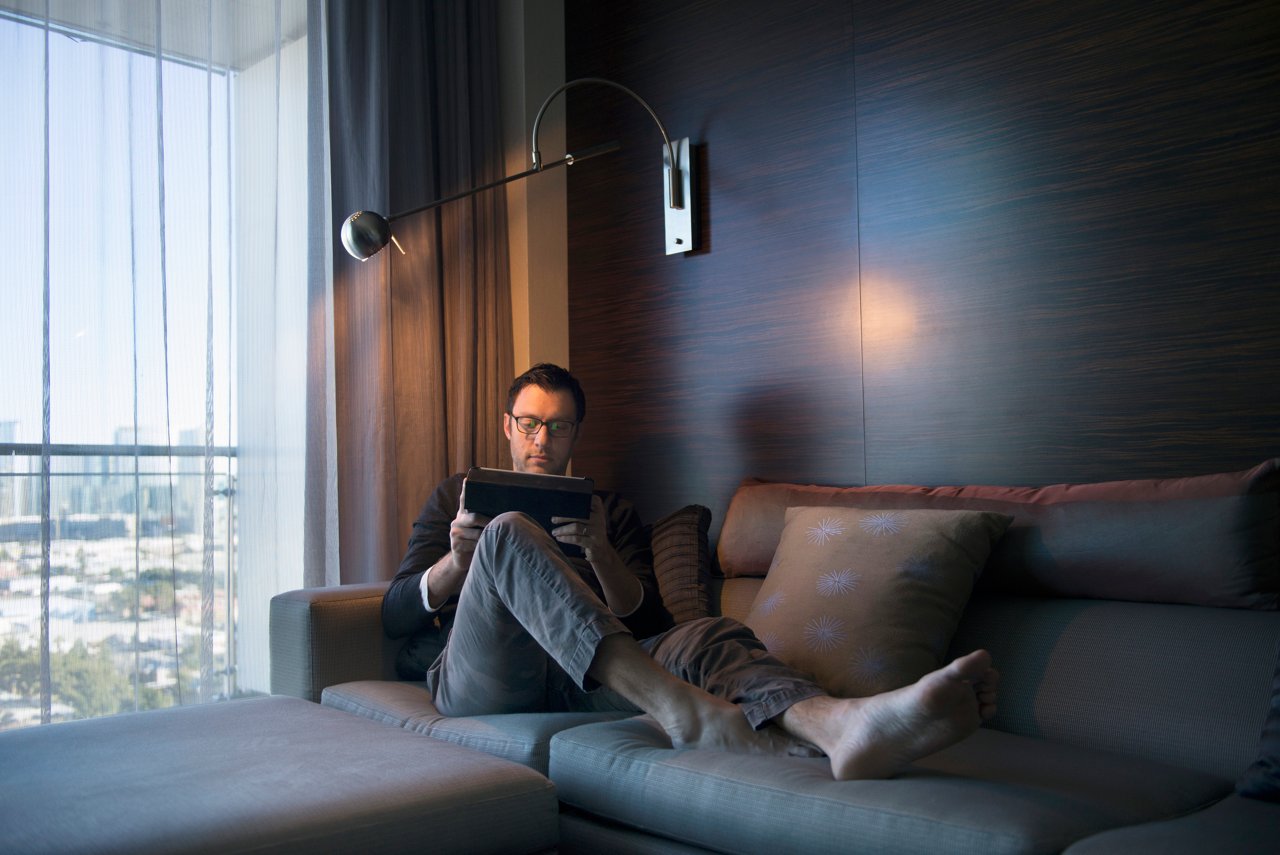Business man working on a tablet from his hotel room