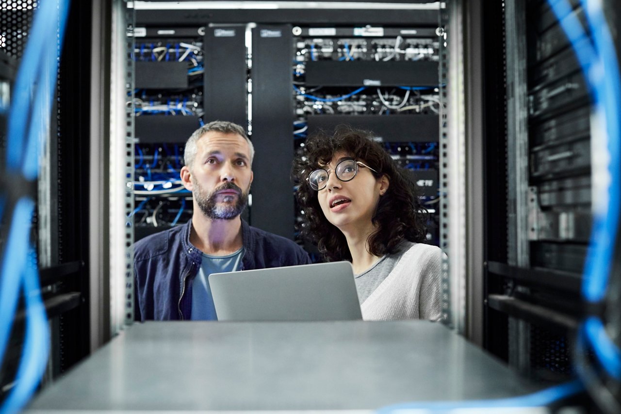 Female technician discussing with male about cables.