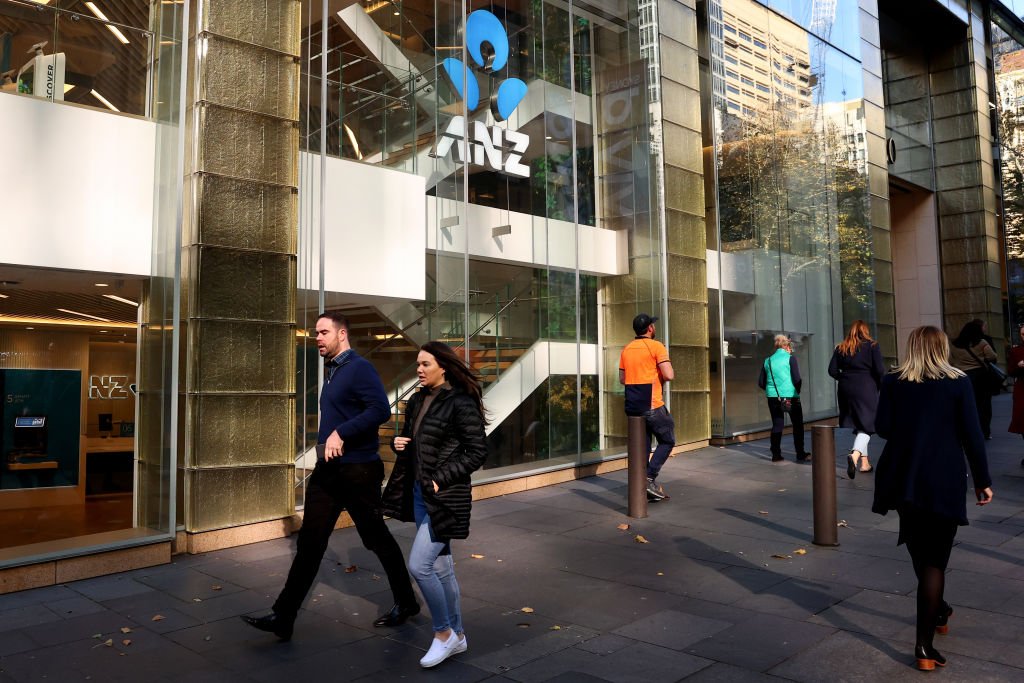 Commuters walk past an ANZ Bank branch