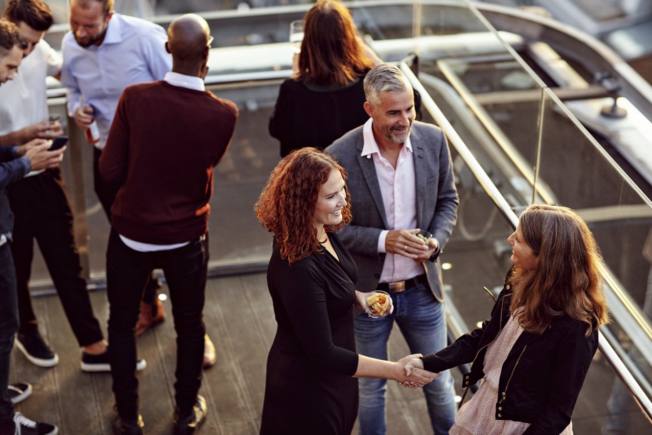 屋上のリフレッシュスペースで交流する会社員の様子