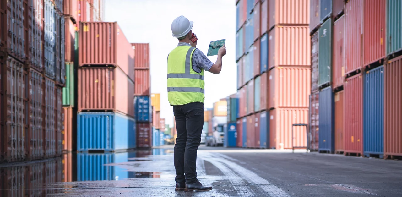 Engineer and tablet at Containers yard from Cargo freight ship for import export.