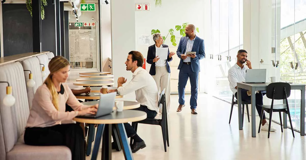 People working at tables in an office.