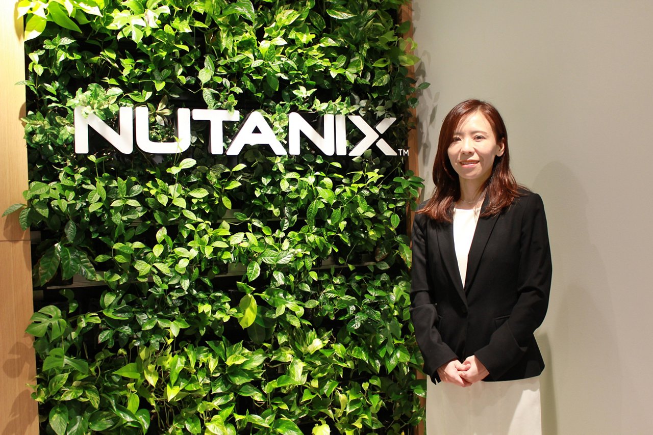 Nutanixのロゴの前に立つ女性