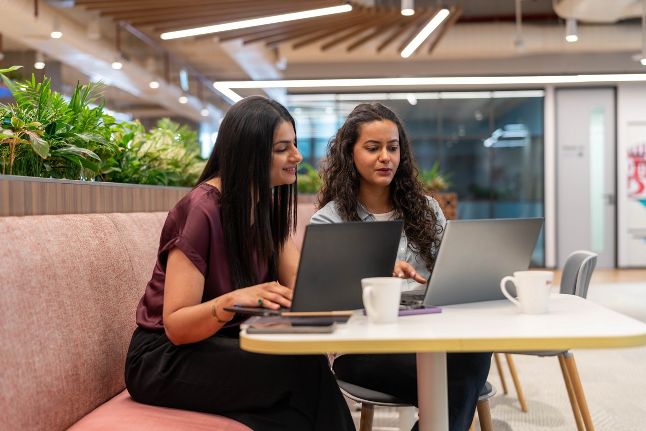 社内カフェでリラックスして打ち合わせしている女性ワーカーたち