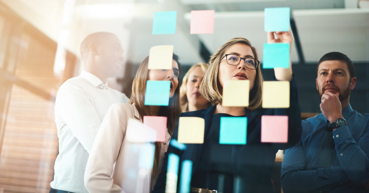  従業員が何かを議論し、付箋を使用している