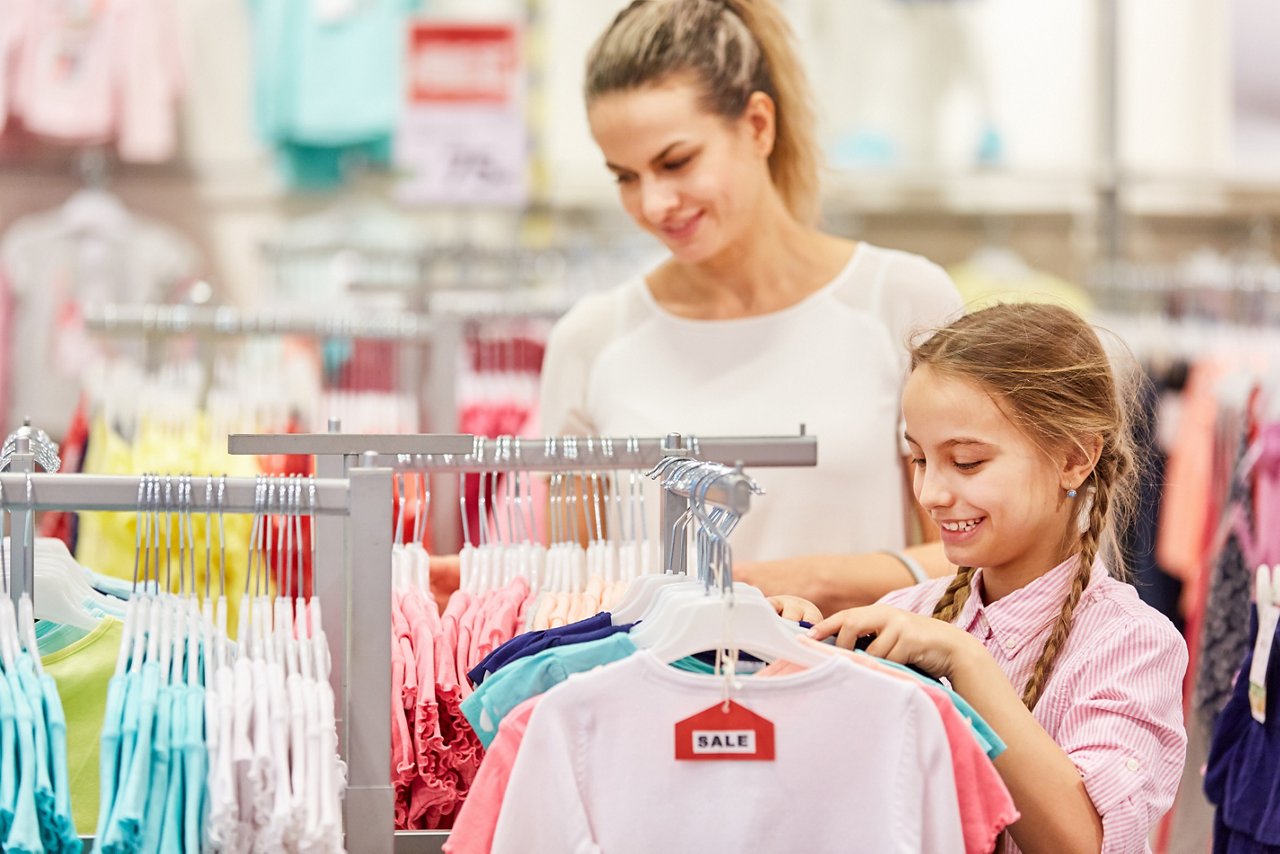 Mother and daughter together while shopping in a mall while on sale