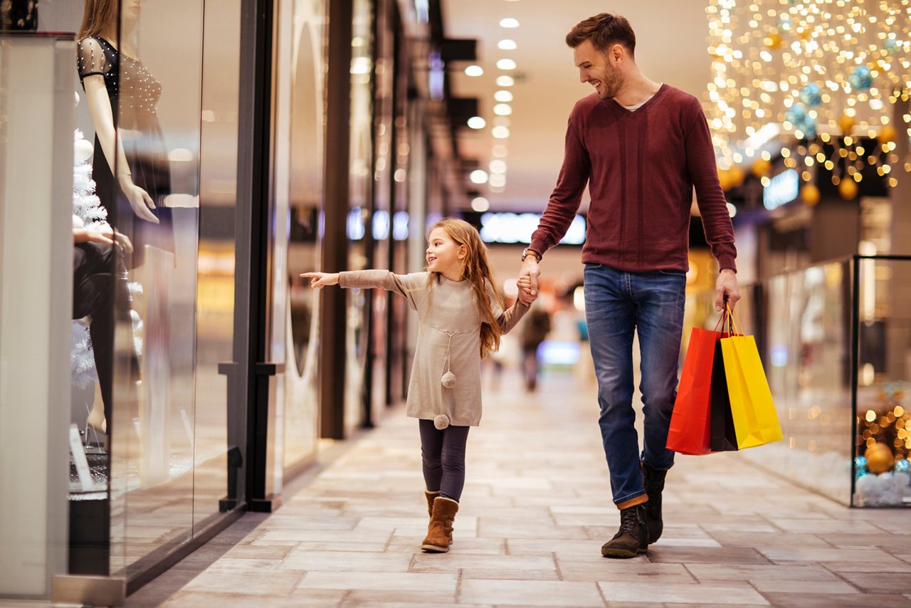 Father and daughter spending a day in shopping mall