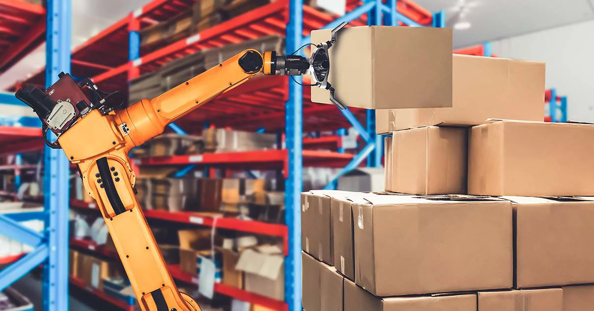 An orange robotic arm handling cardboard boxes in a warehouse setting.