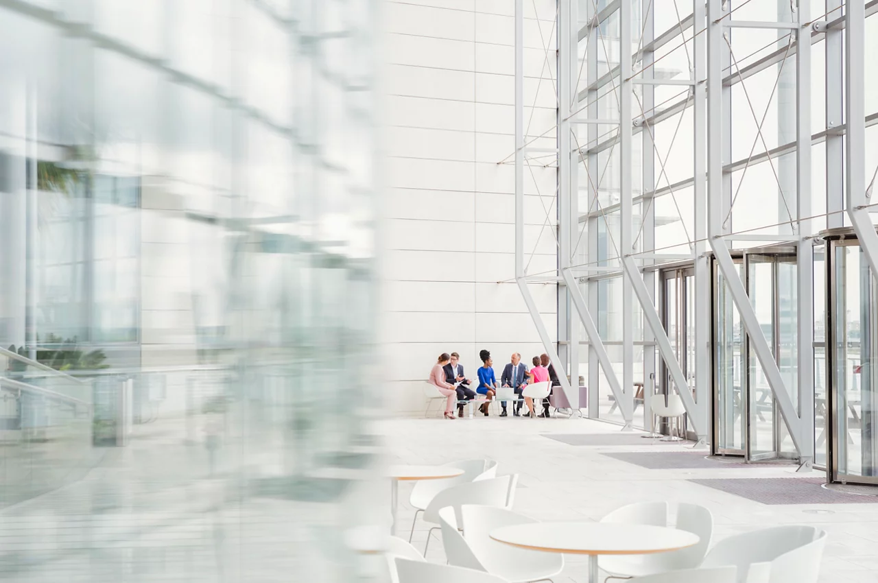 People sat down in a meeting in glass building