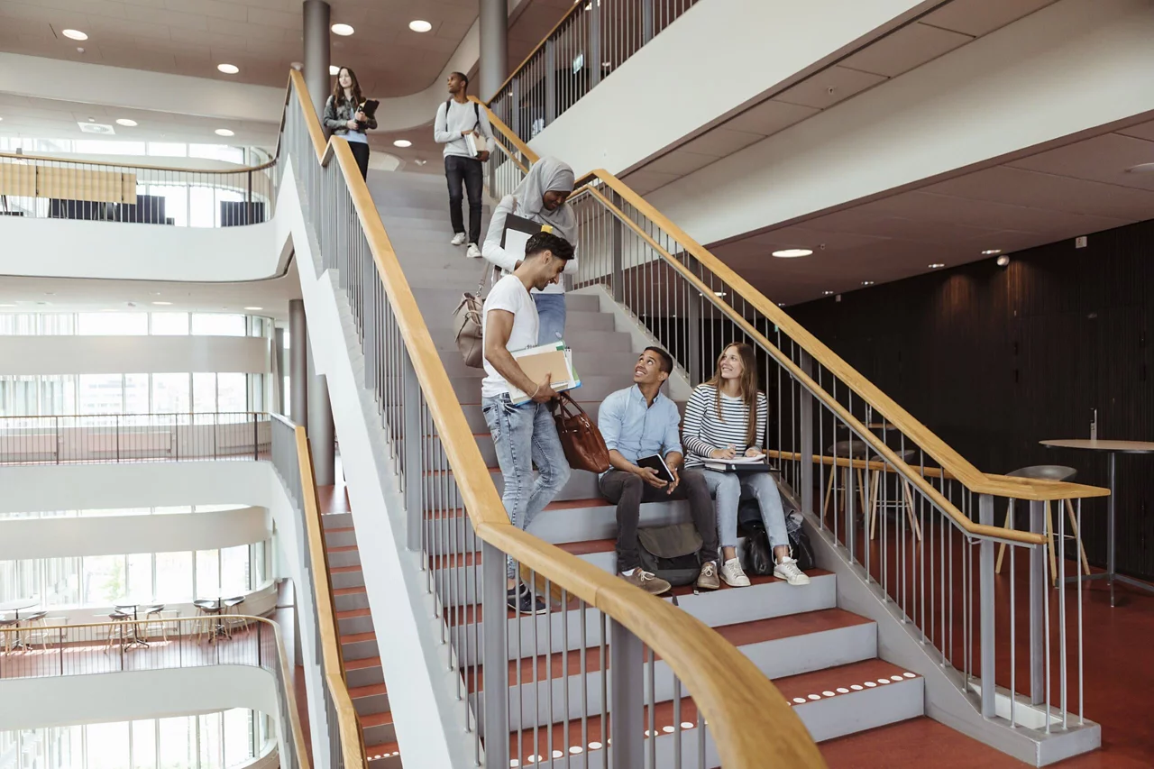 Students collaborating in a modern, open-plan campus space with natural light