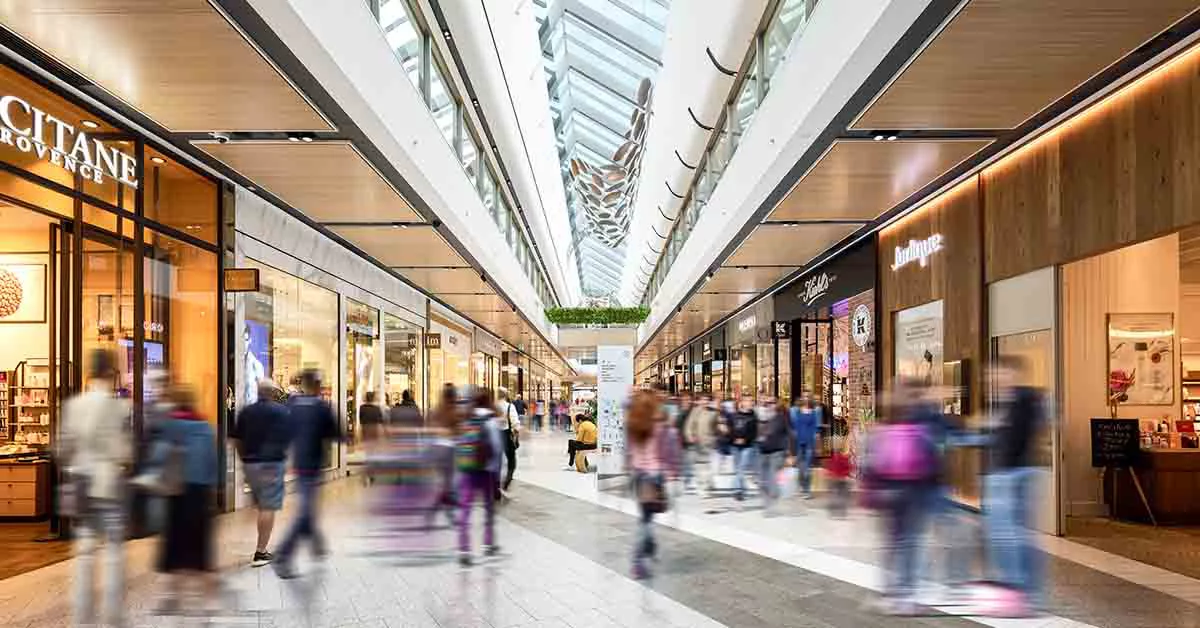 Individuals walking in a crowded shopping mall.