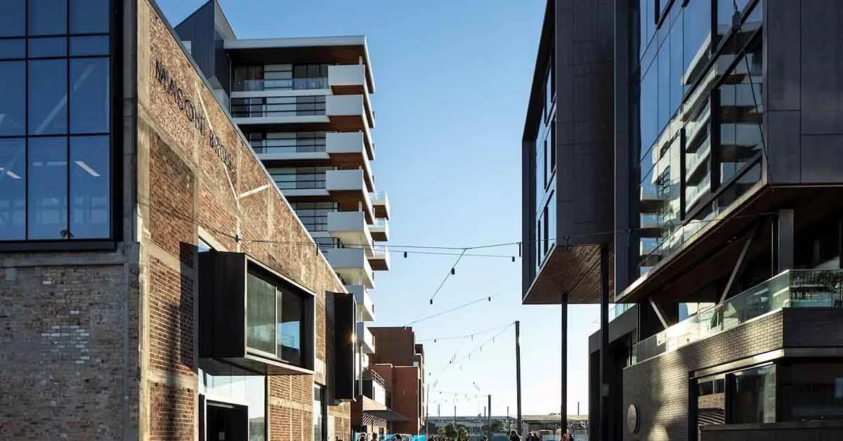 A street scene featuring a brick building alongside a parked car.