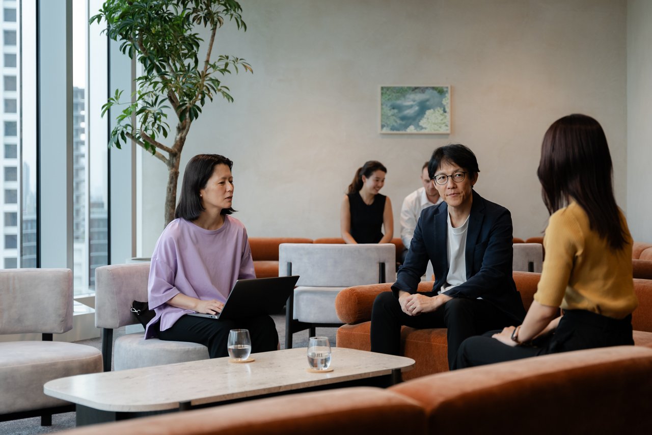 オフィスビルの共用ラウンジで打ち合わせするテナント企業の社員（画像はイメージ）