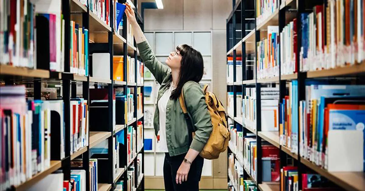 A woman taking one of the book in library