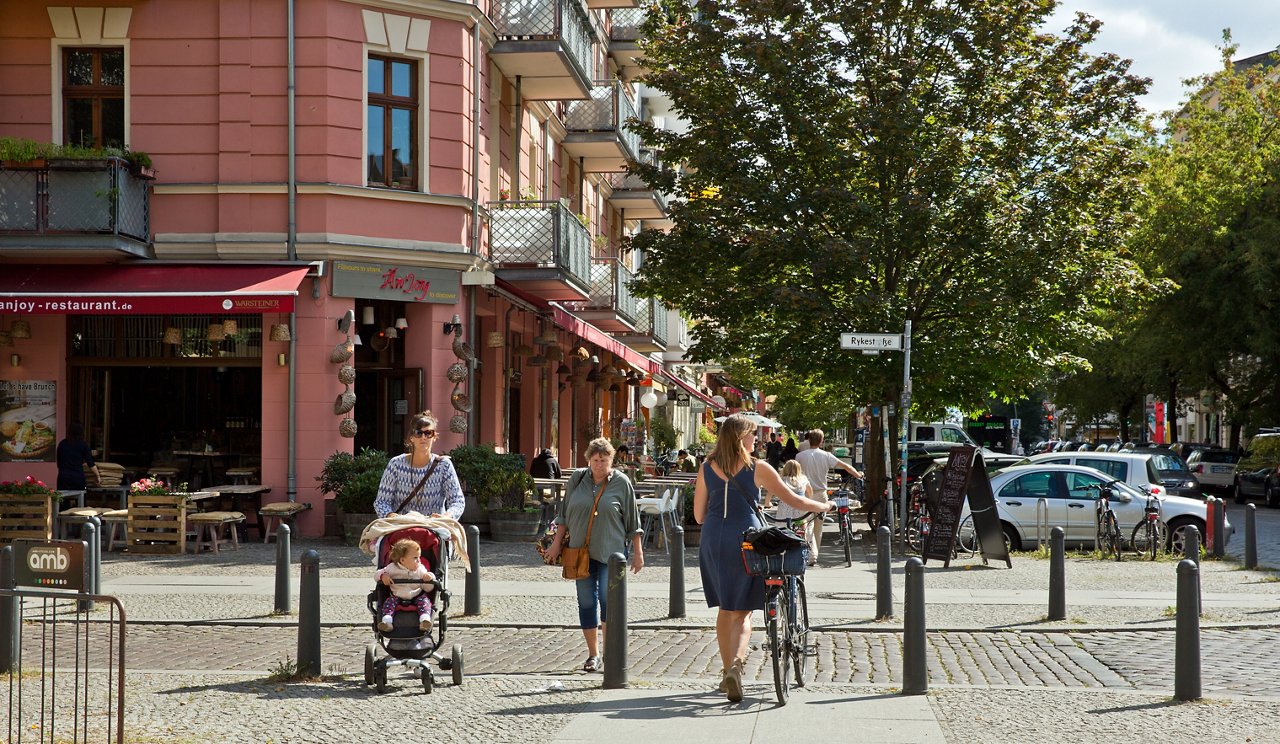 Women walking on streets with cycle and stroller