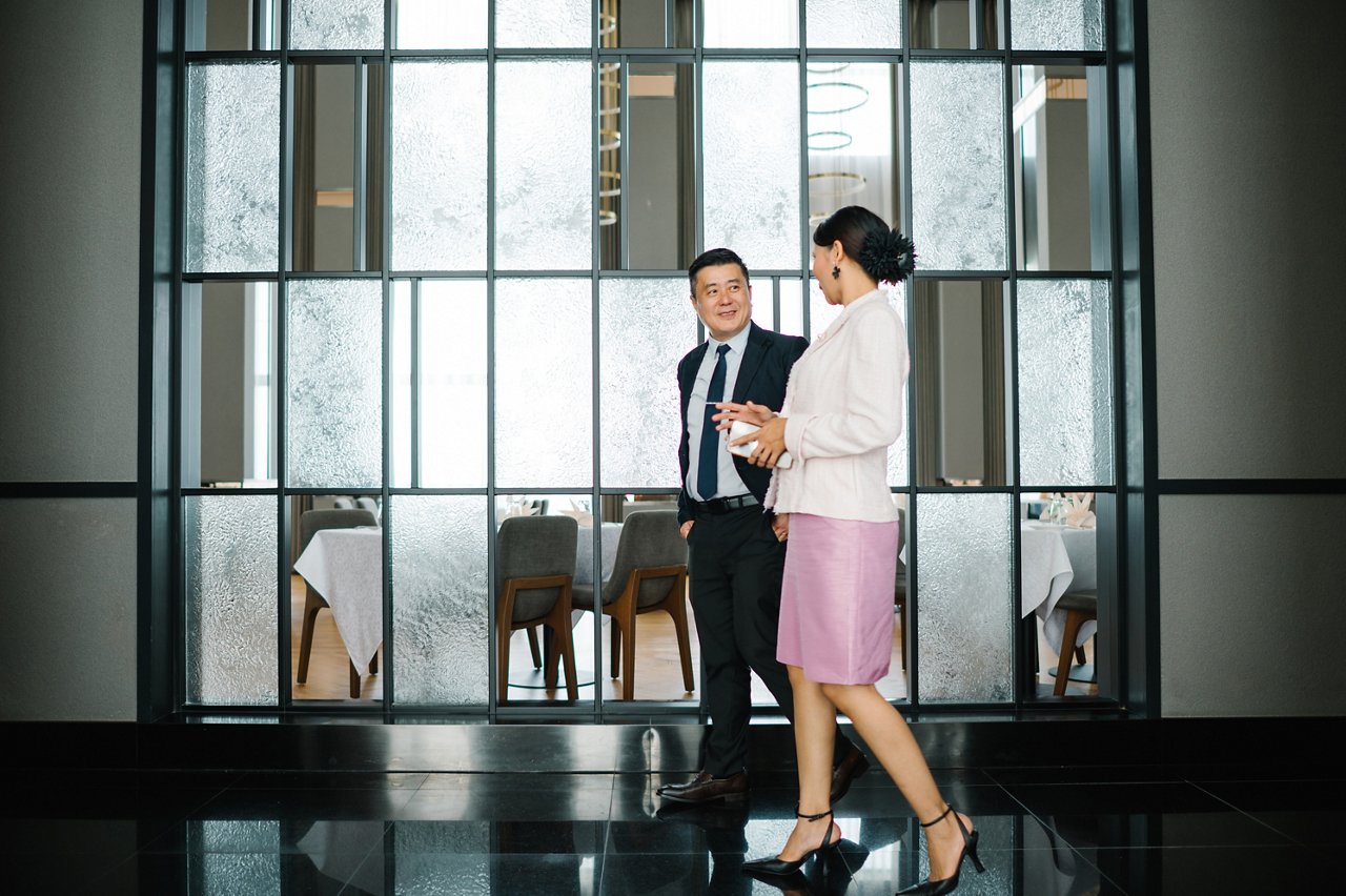 Asian Chinese CEO is talking to secretary on corridor in a hotel.