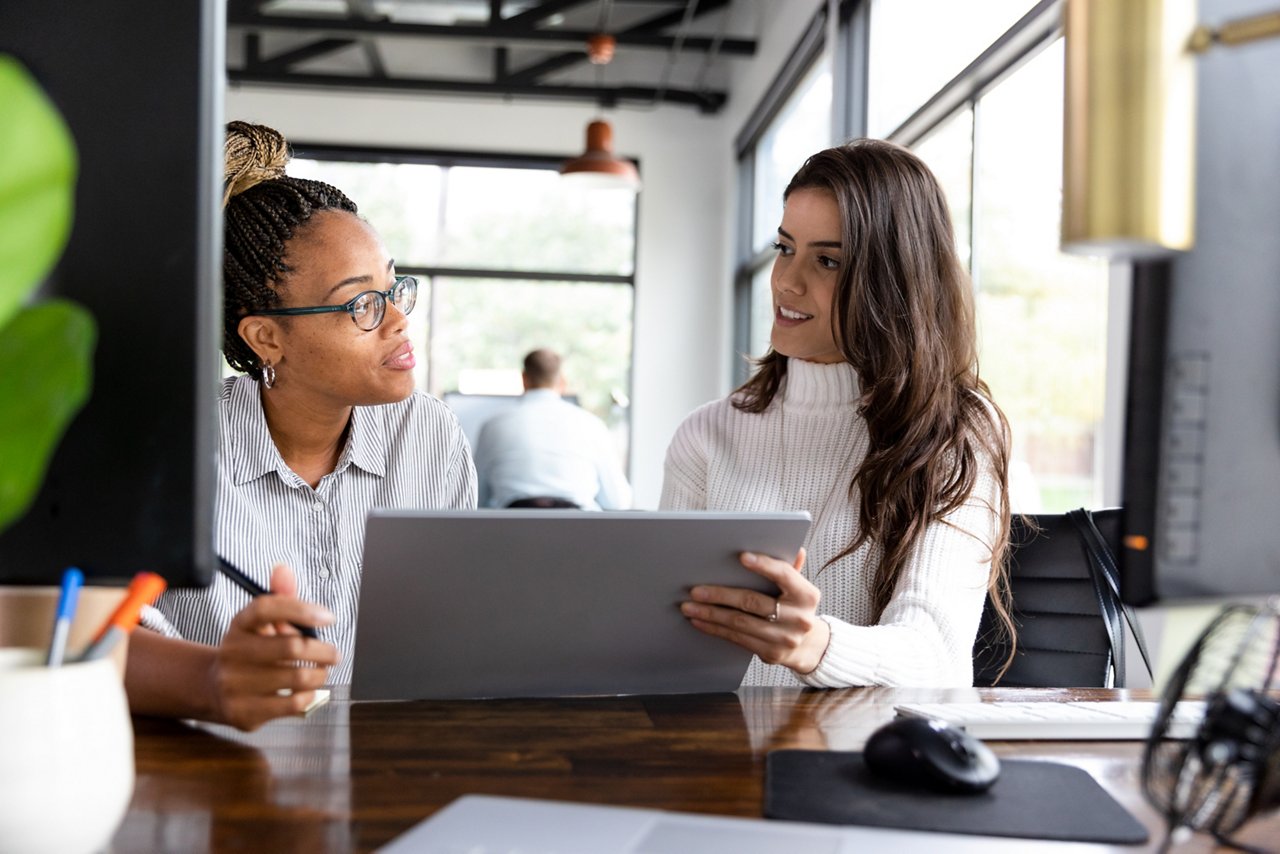 Mid adult female business partners meet in a co-working space to plan for the next year.