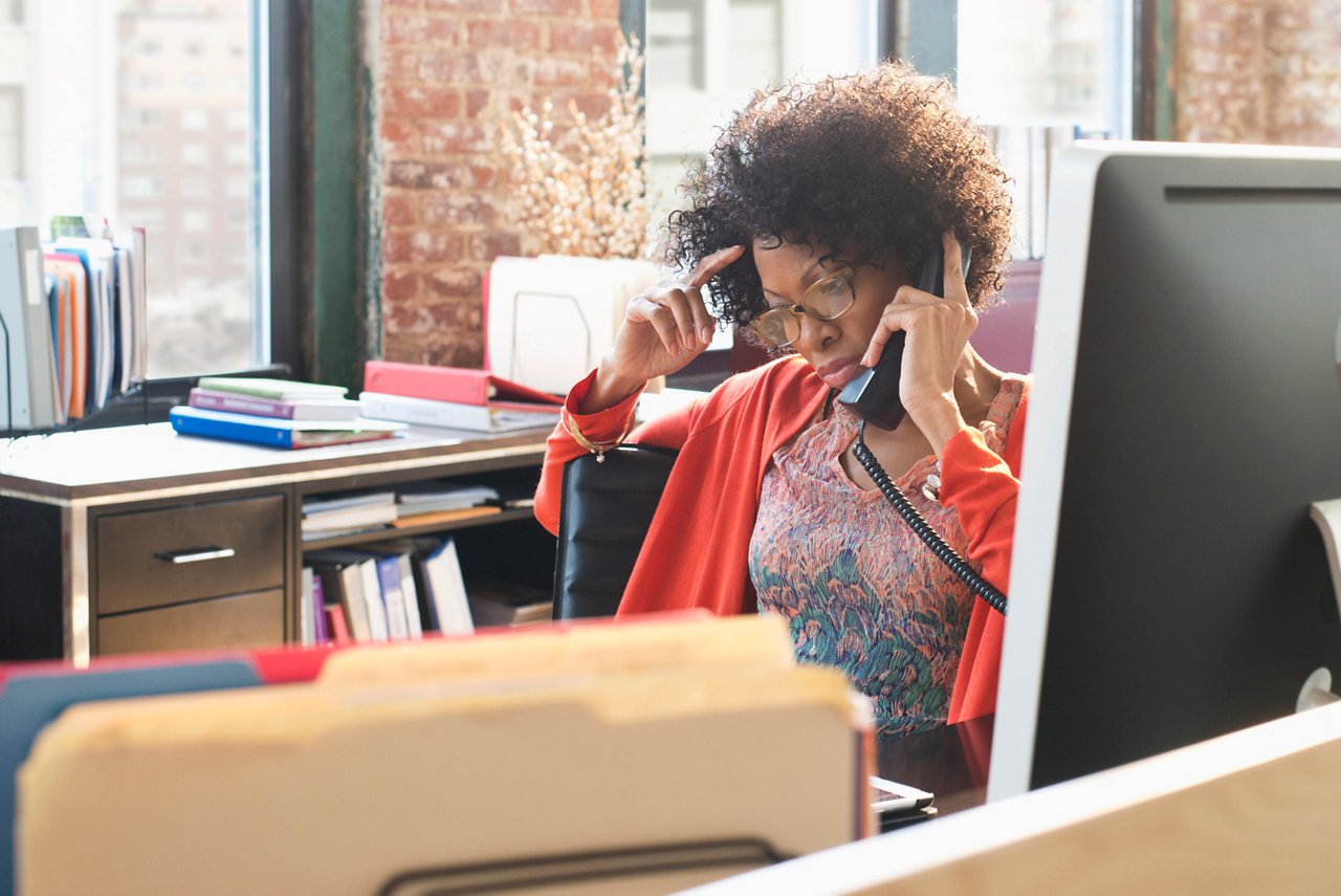 Black businesswoman talking on telephone at desk