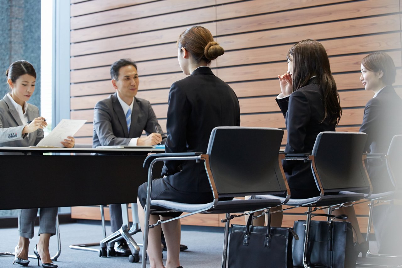 企業の人事担当者と学生が集団面接をしている様子