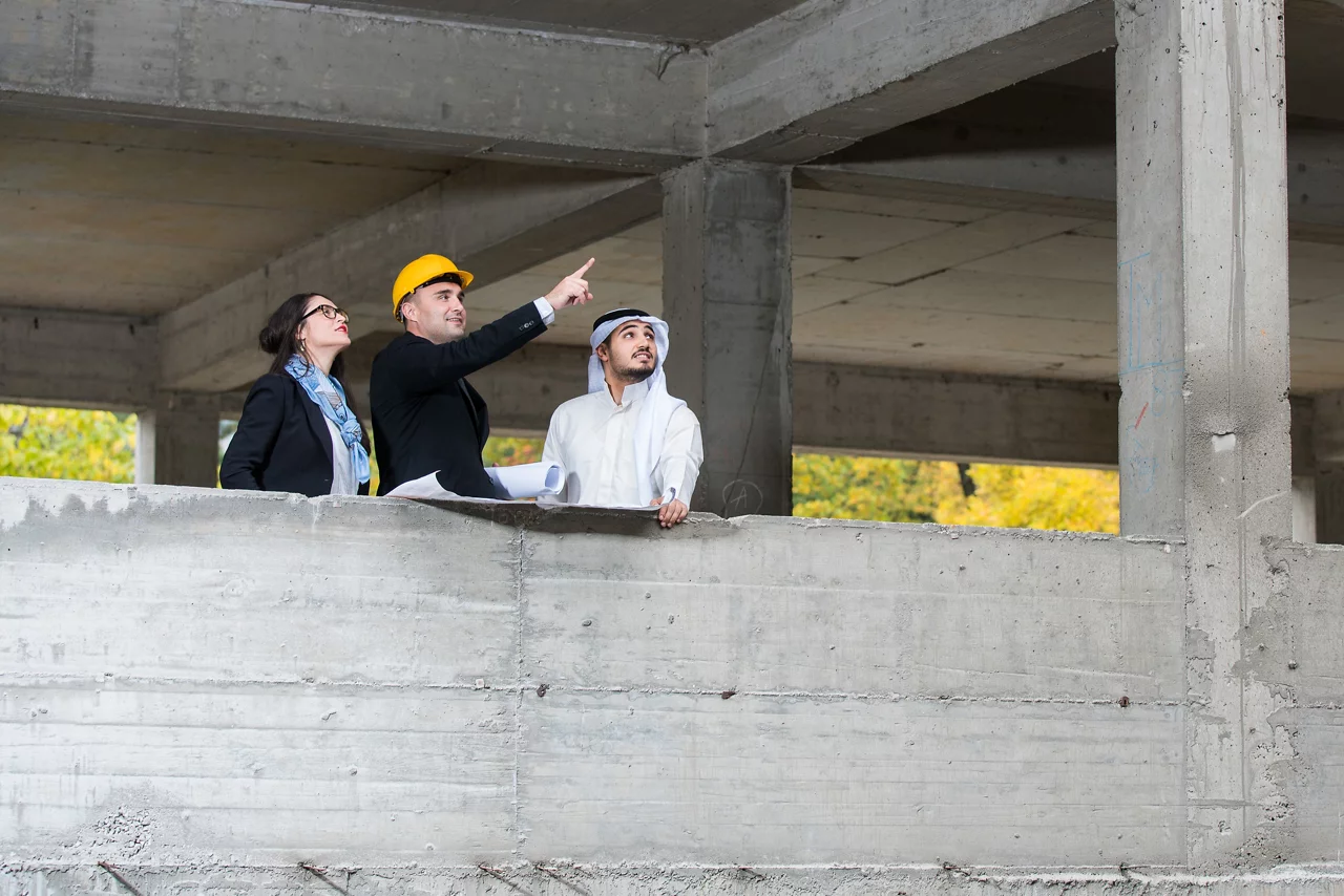 مديرة البناء والمهندسة مع رجل المستثمر يعملان في موقع البناء