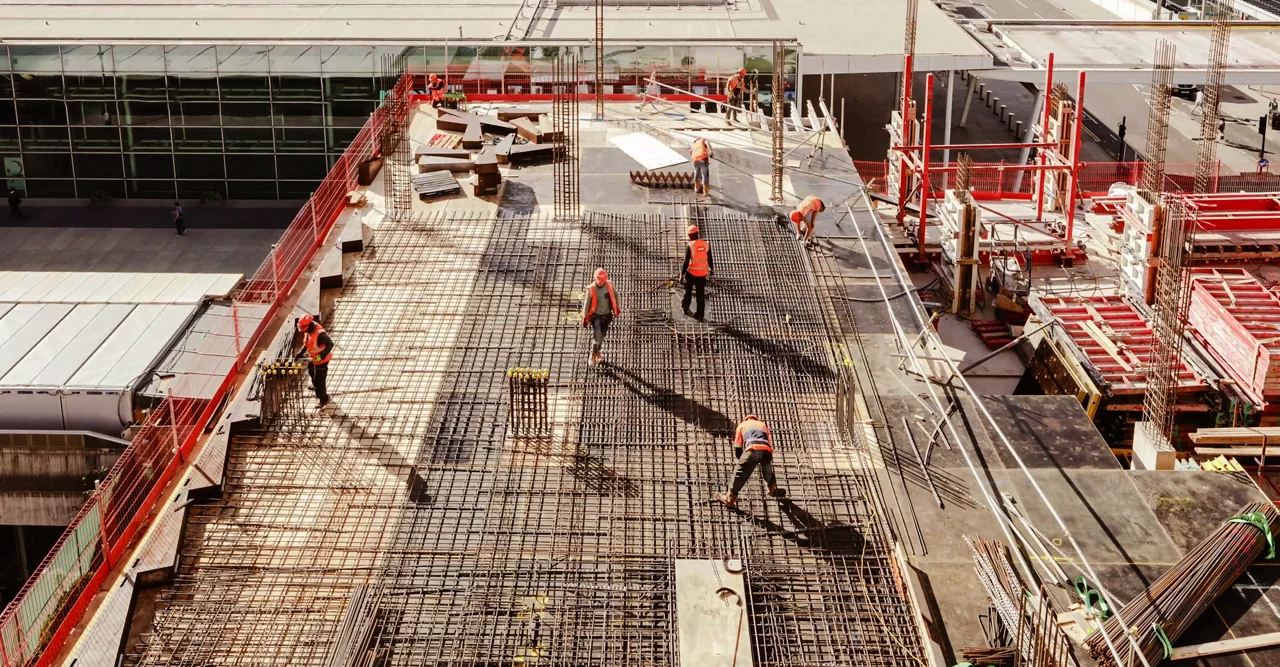 Construction workers at a construction site viewed from above, High angle view of five people with helmets.