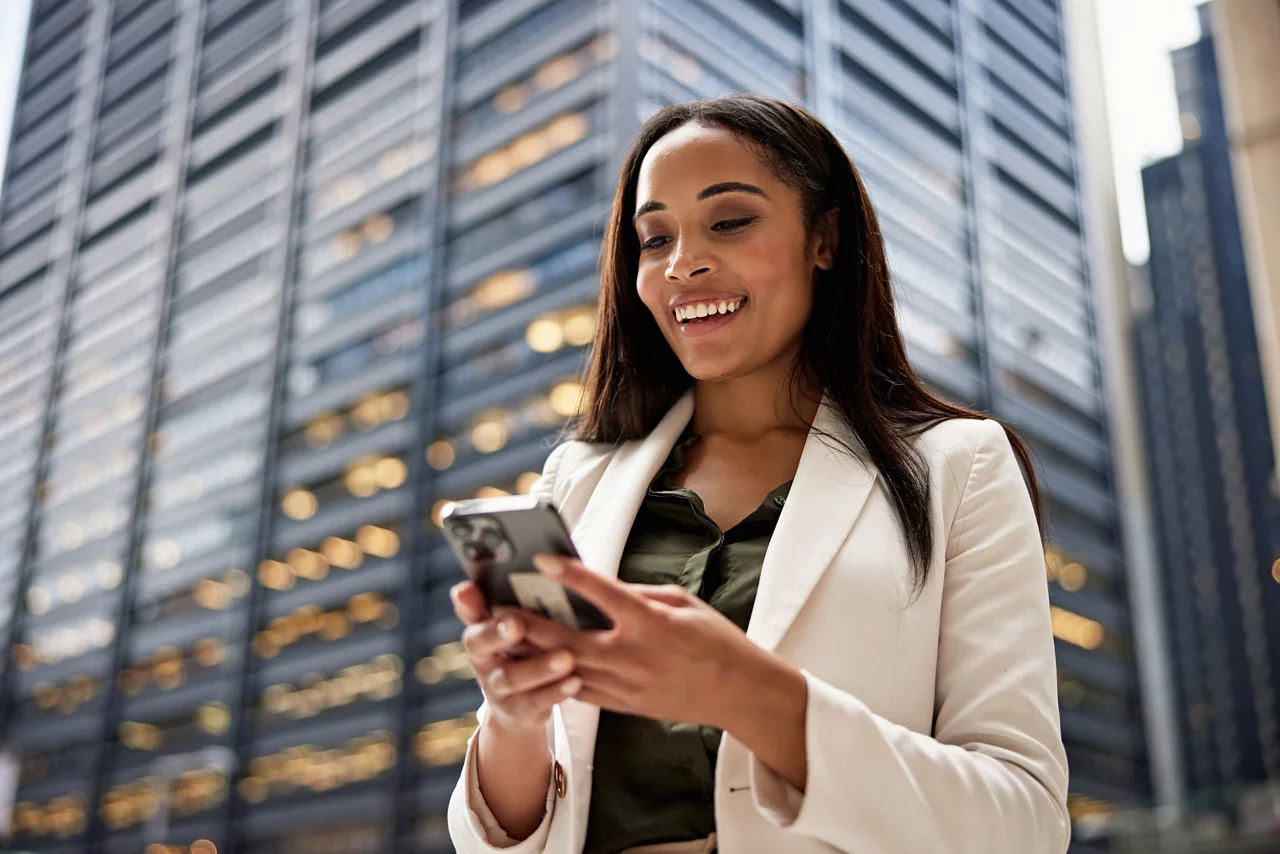 Black professional in late 20s wearing office attire and communicating on portable device