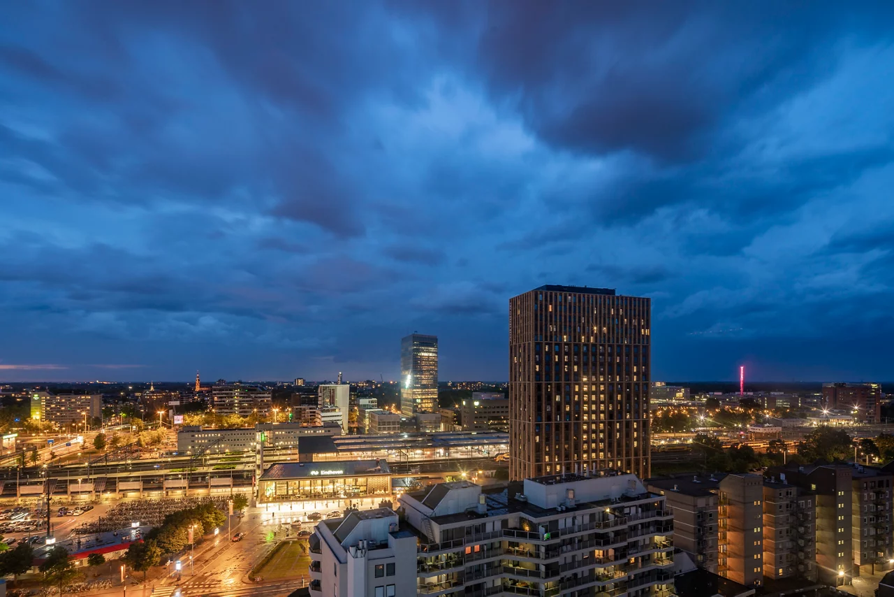 een dramatisch avondstadsgezicht met een moderne stedelijke skyline onder stormachtige blauwe wolken
