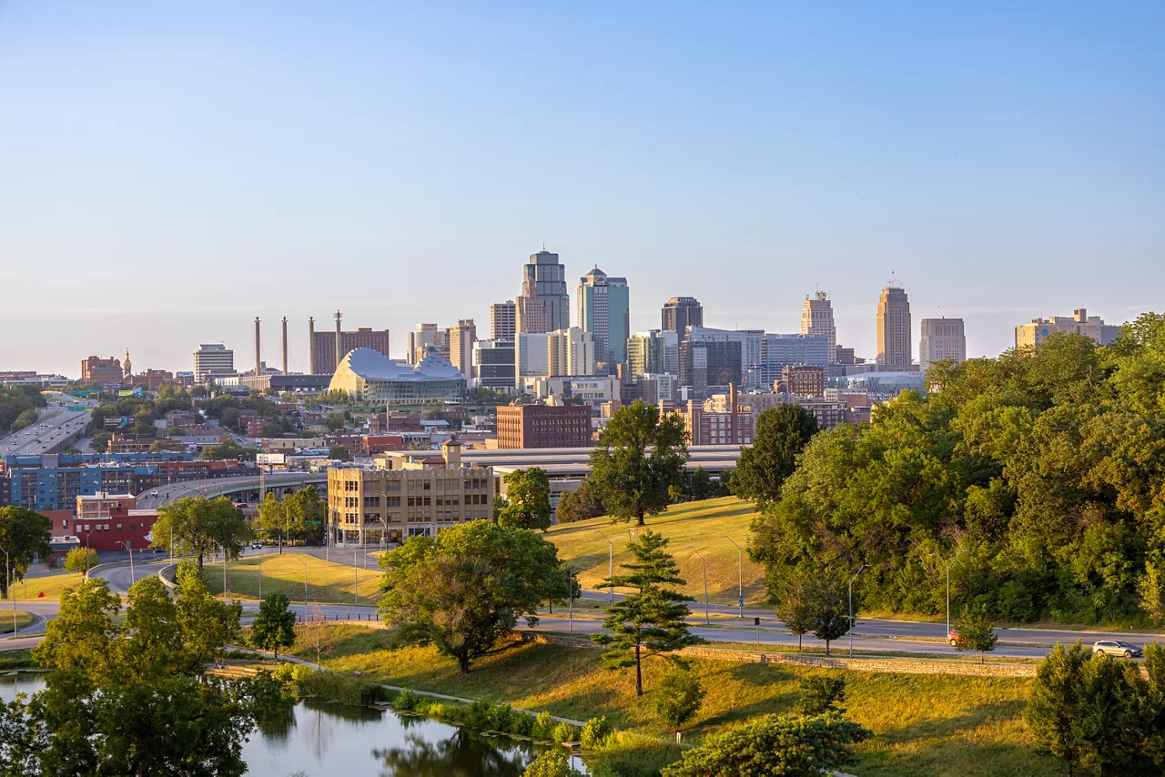 The skyline of Kansas City glows with the lights of skyscrapers and bridges, reflecting the vibrant urban life. 