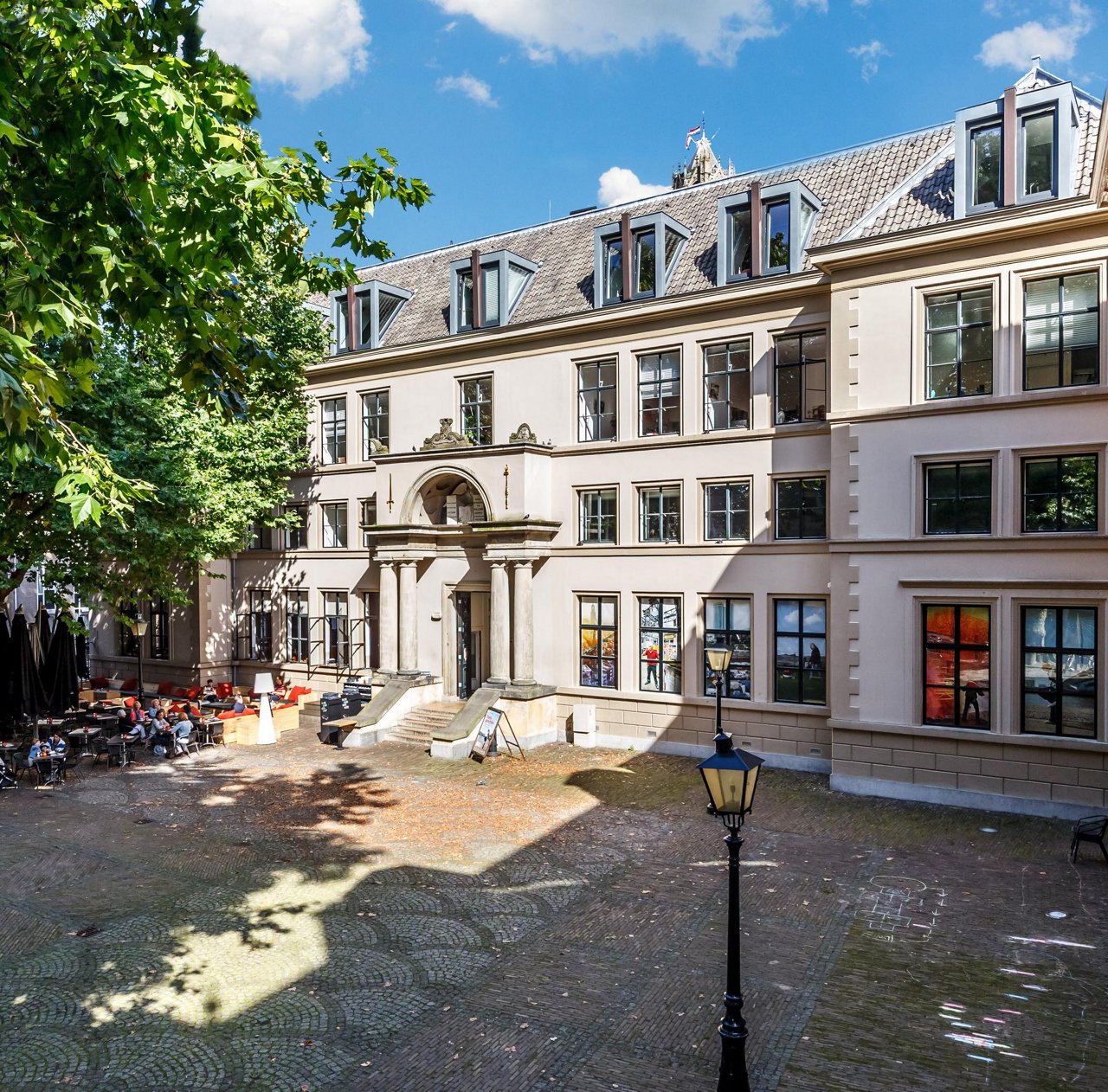 Historisch gebouw met meerdere verdiepingen, grote ramen en een gewelfde ingang