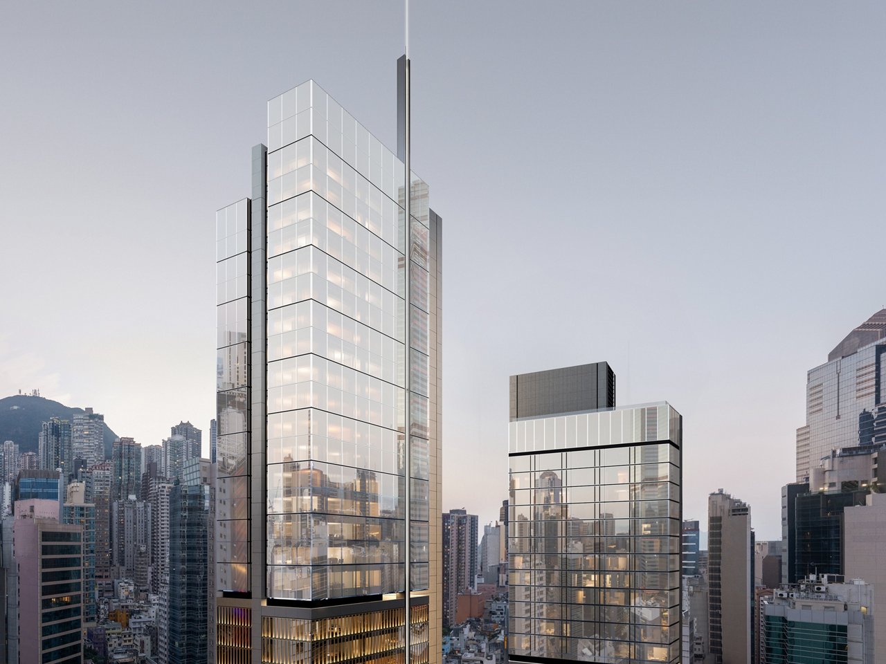 Two modern high-rise towers with glass facades and contemporary architectural design stand prominently in a dense urban cityscape