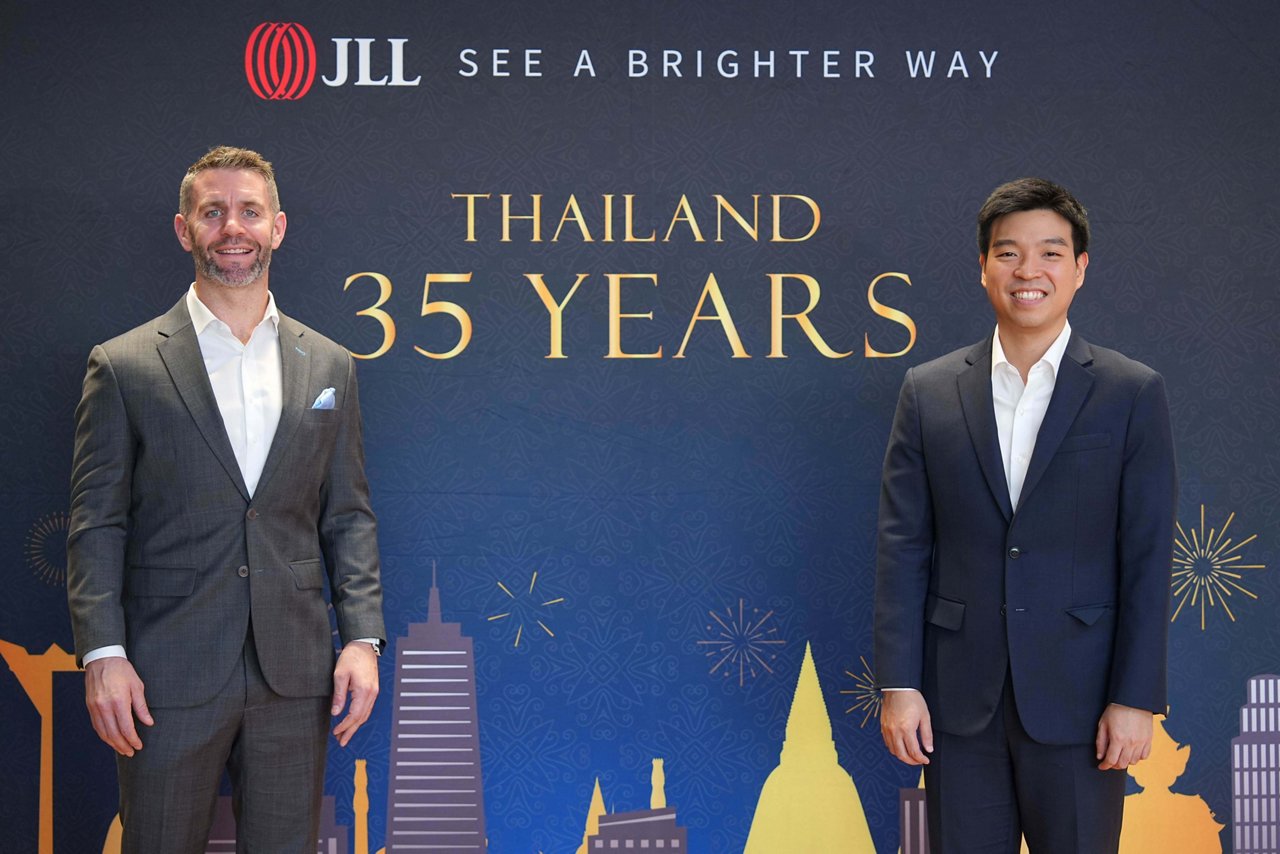Two men with picture of thailand celebrating 35years