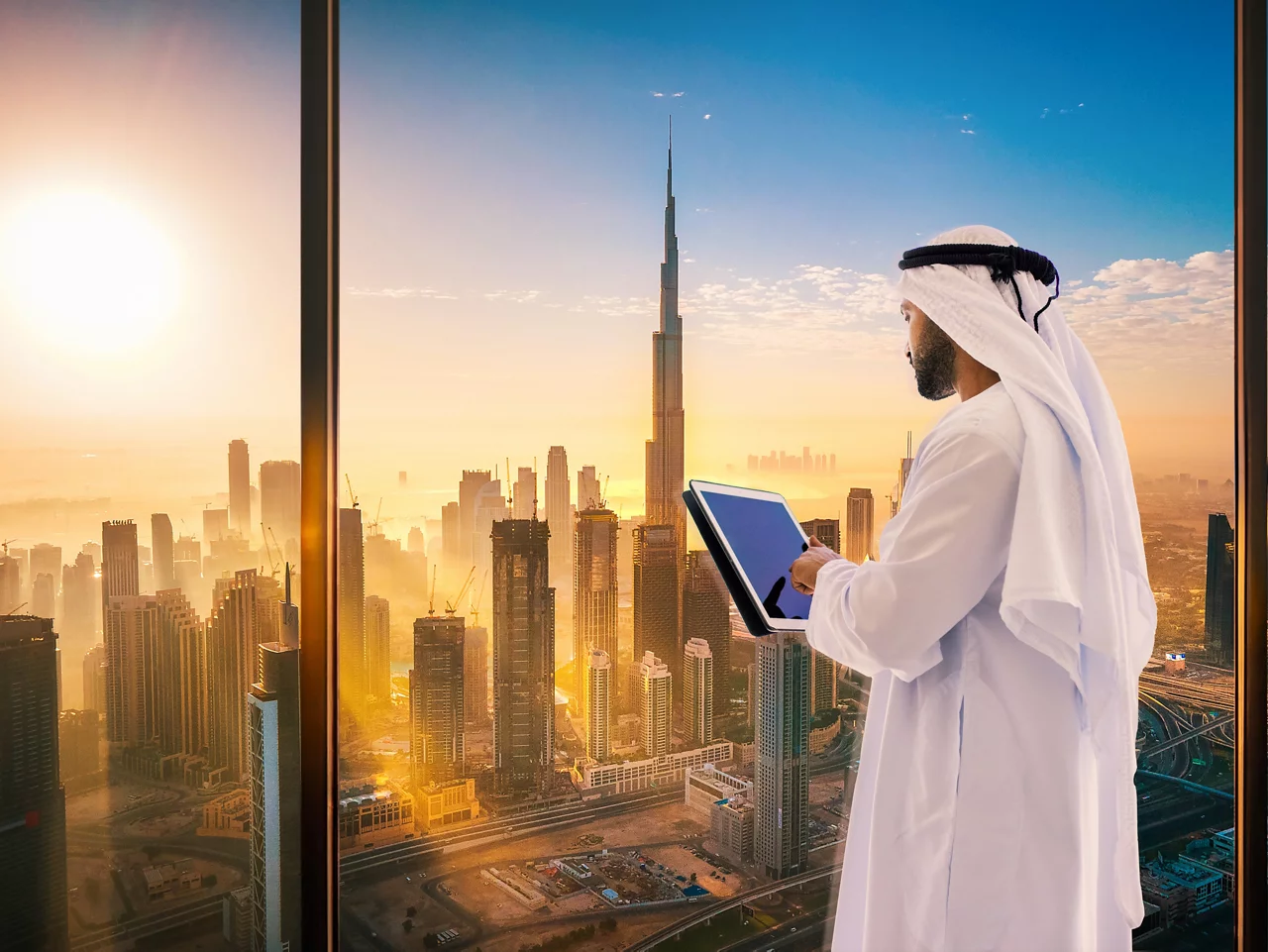 Aerial skyline of downtown Dubai filled with modern skyscrapers in the United Arab Emirates rising above the main city highway aerial view at sunrise