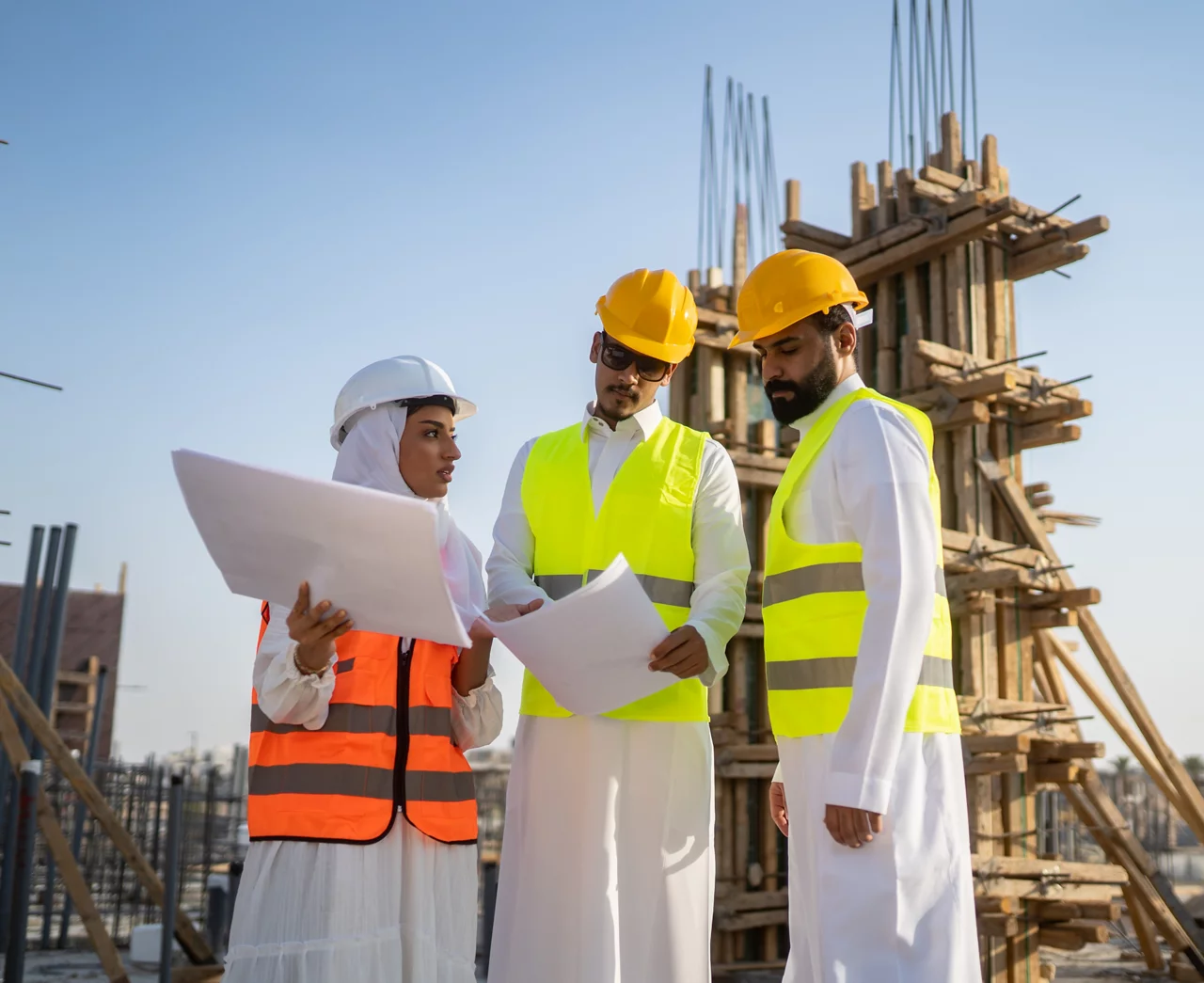 تقوم النساء بفحص المبنى قيد الإنشاء مع المهندس في موقع البناء.