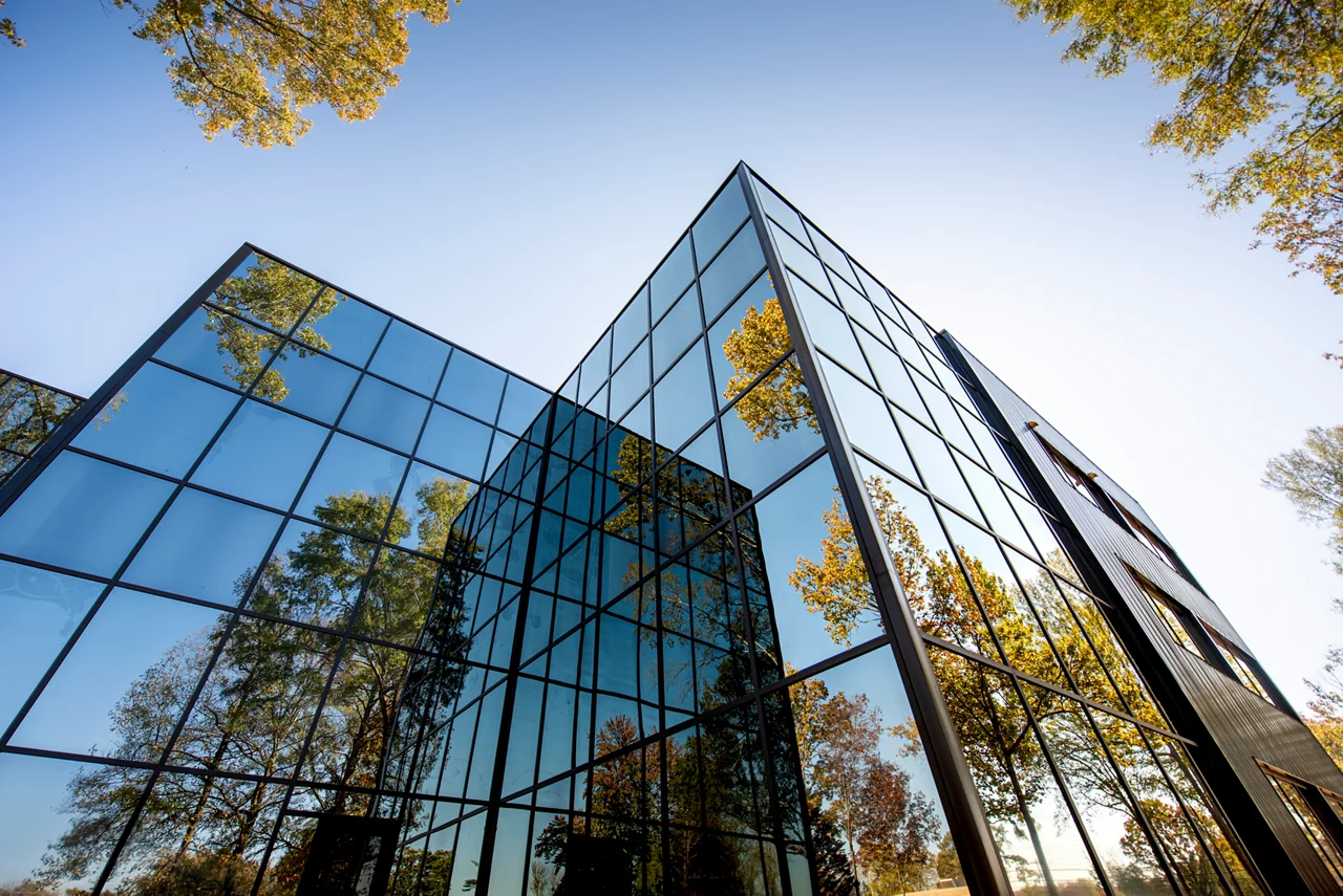 Office building with trees reflected in glass